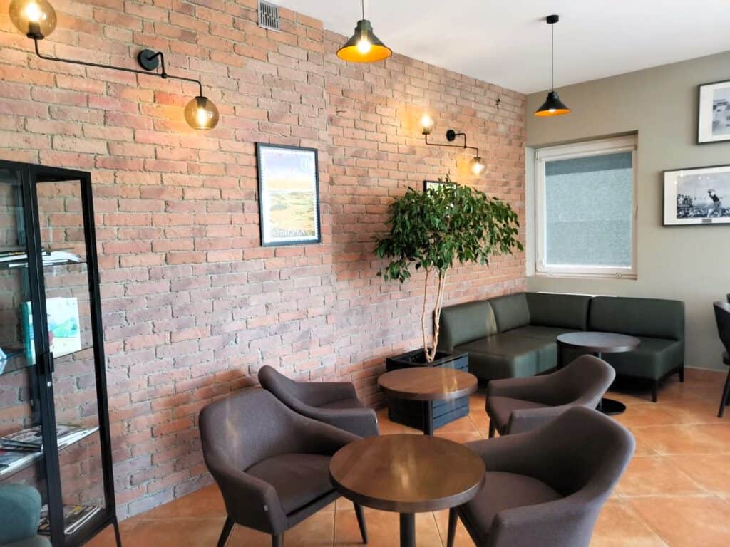 Restauracja Lisia Polana to kawiarnia, która emanuje przytulną atmosferą dzięki uroczym stołom i krzesłam ustawionym na rustykalnym tle ceglanego muru.