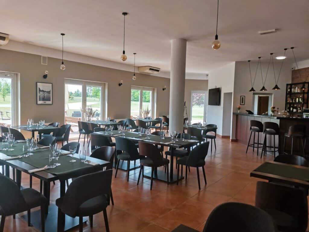 Restauracja Lisia Polana to restauracja ze stołami i krzesłami na środku sali.